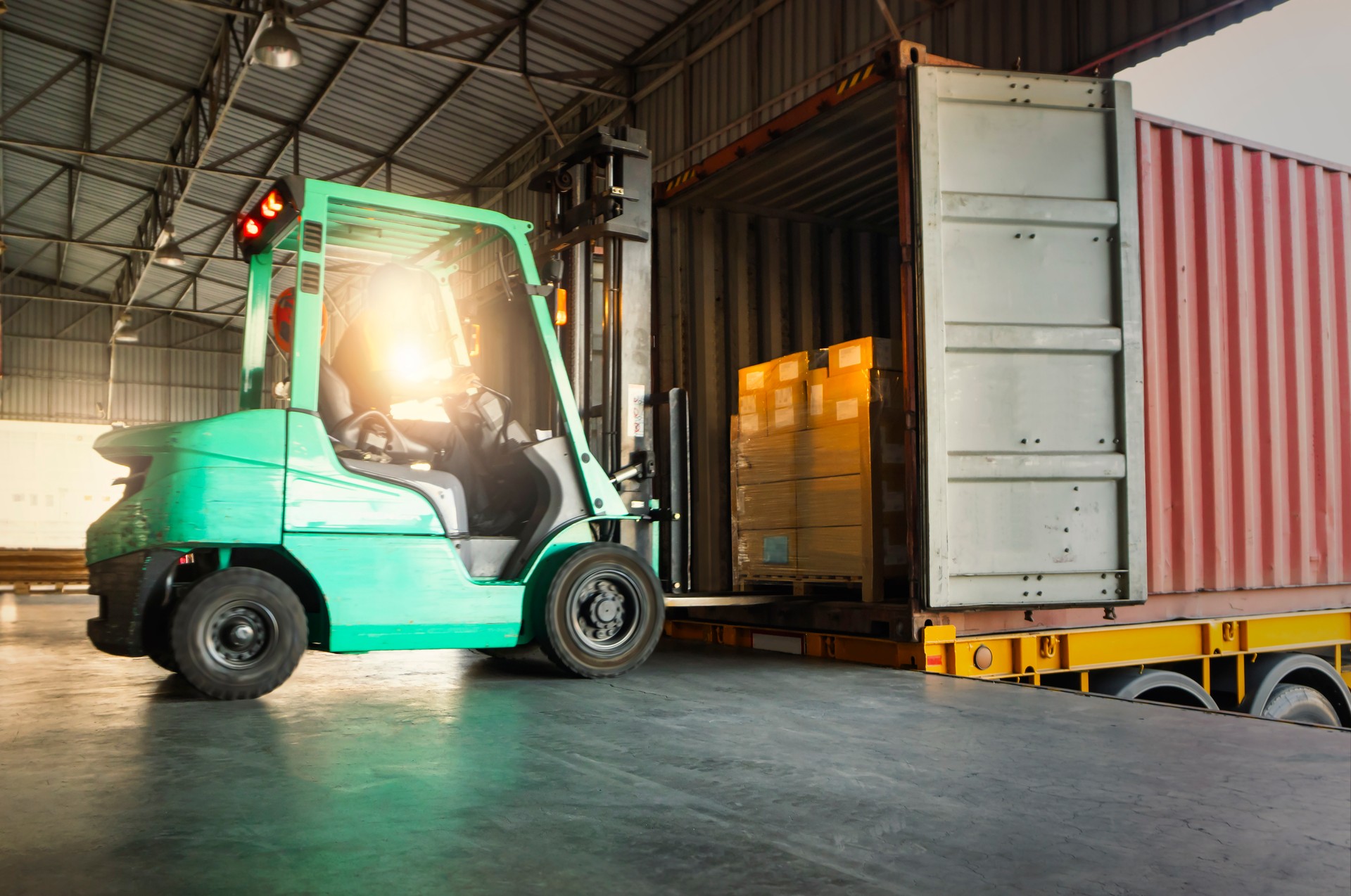 Forklift Tractor Loading Packaging Boxes into Shipping Container at Dock Warehouse. Delivery Cargo Trucks Service. Warehouse Logistics. Shipment Freight Truck Transportation